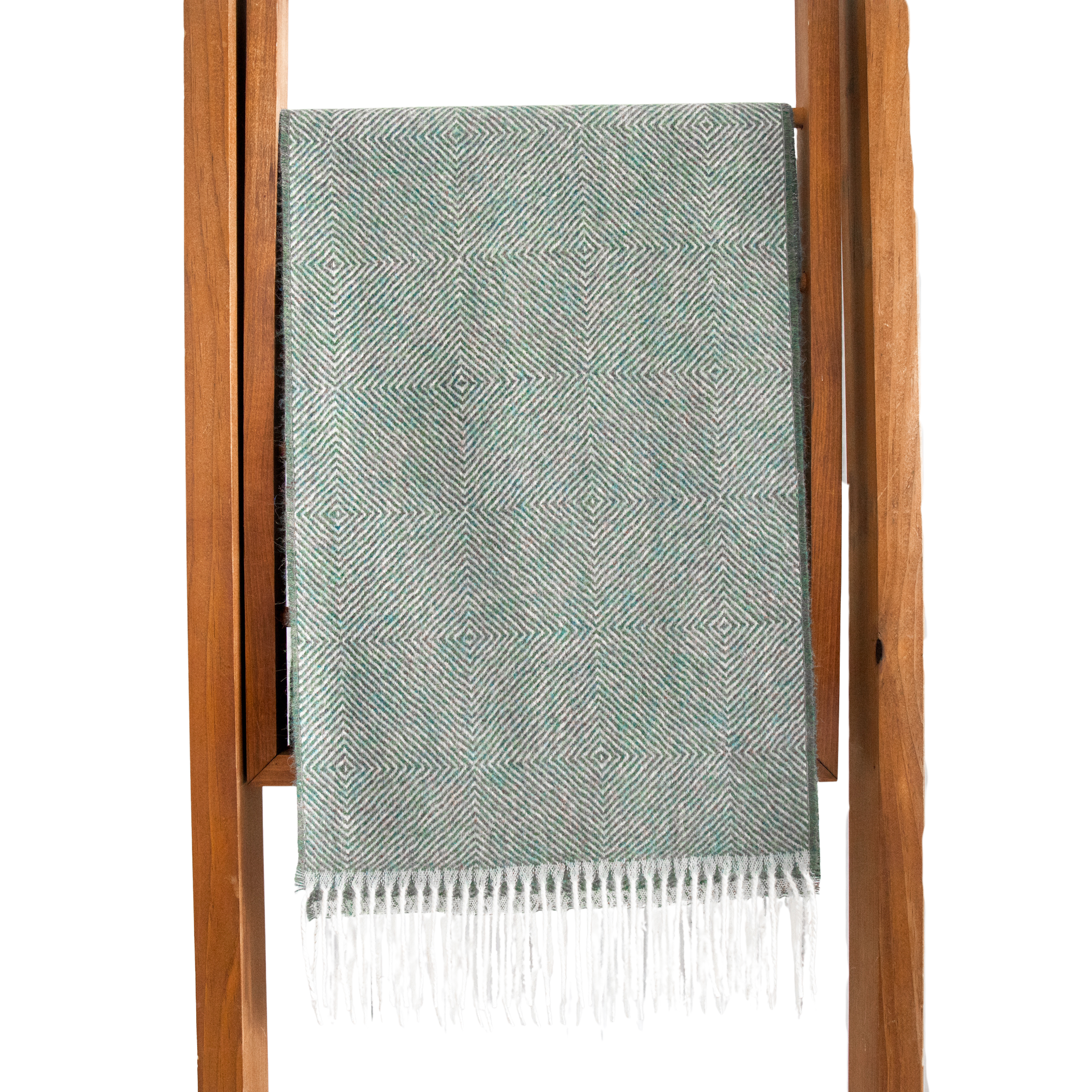 Teal woven blanket with white fringe on a wooden stand against a white background