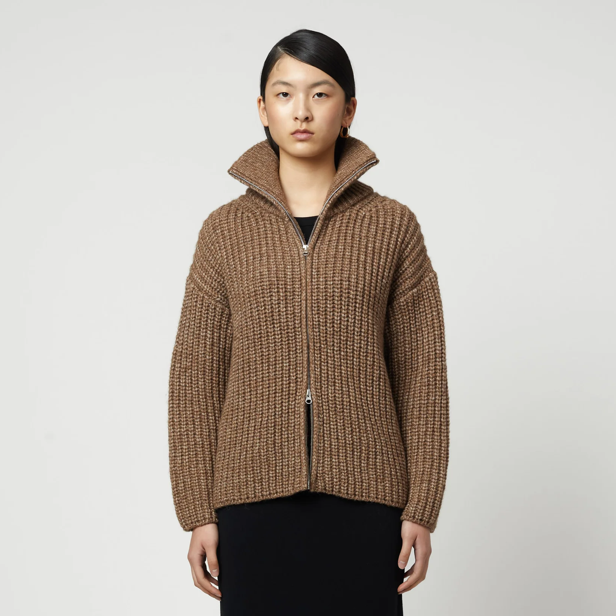 Woman wearing a brown ribbed knit zip-up turtleneck cardigan.
