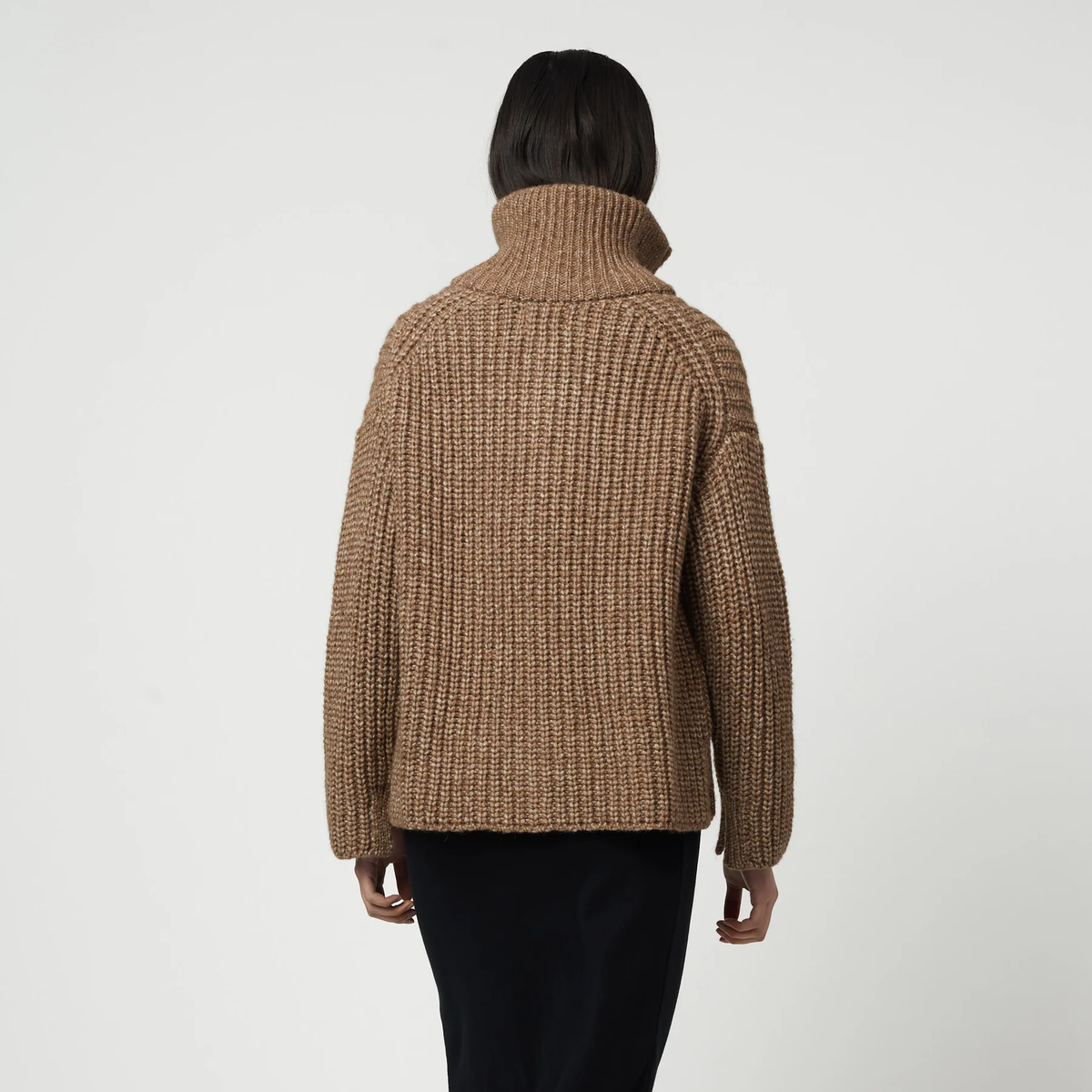 Woman wearing a brown ribbed knit zip-up turtleneck cardigan.