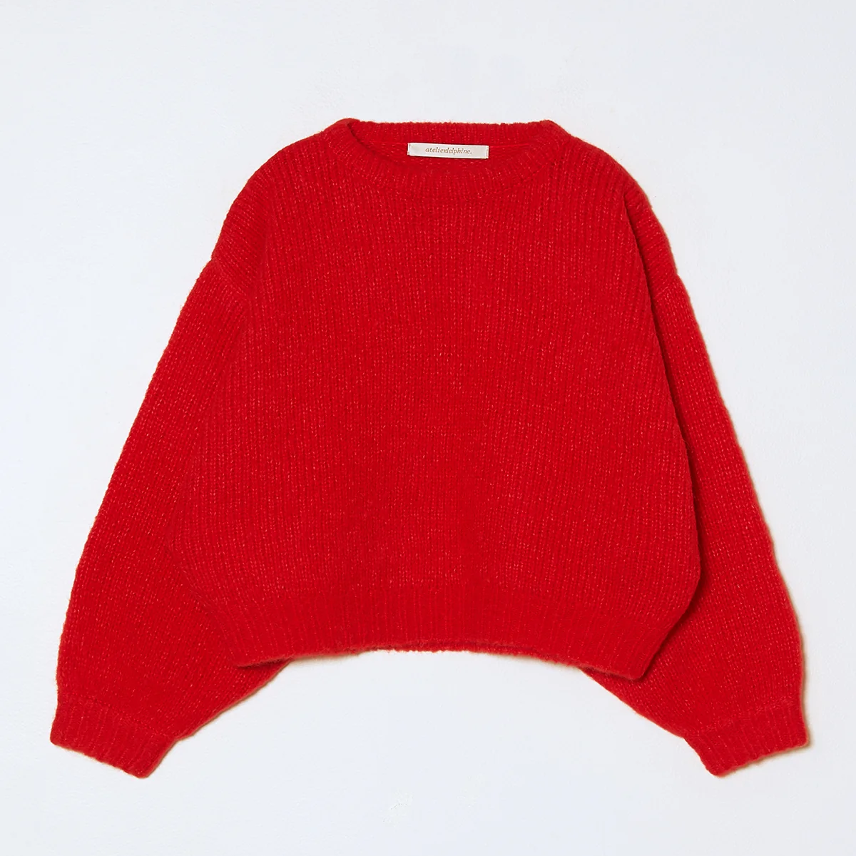 Knit cropped balloon sleeve sweater in bright red on a neutral background.