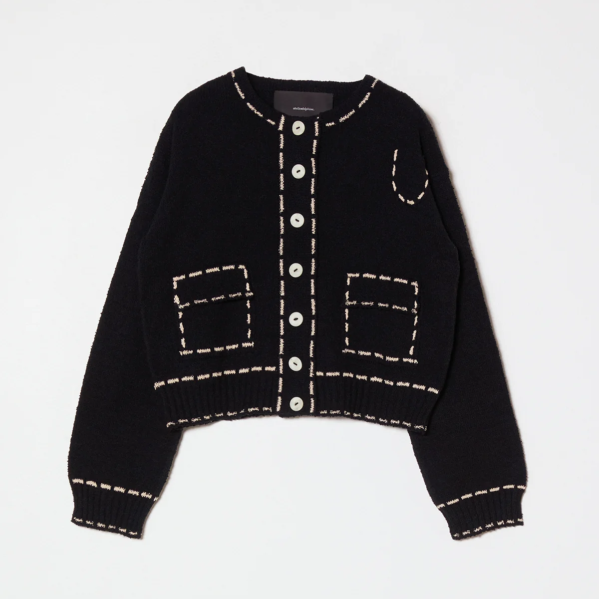 Black cardigan with tan stitching on a light gray background
