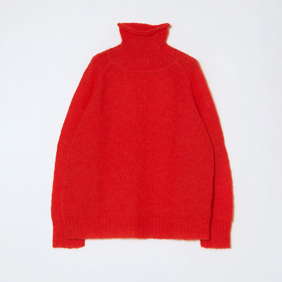Knit bright red turtleneck sweater on a neutral background.