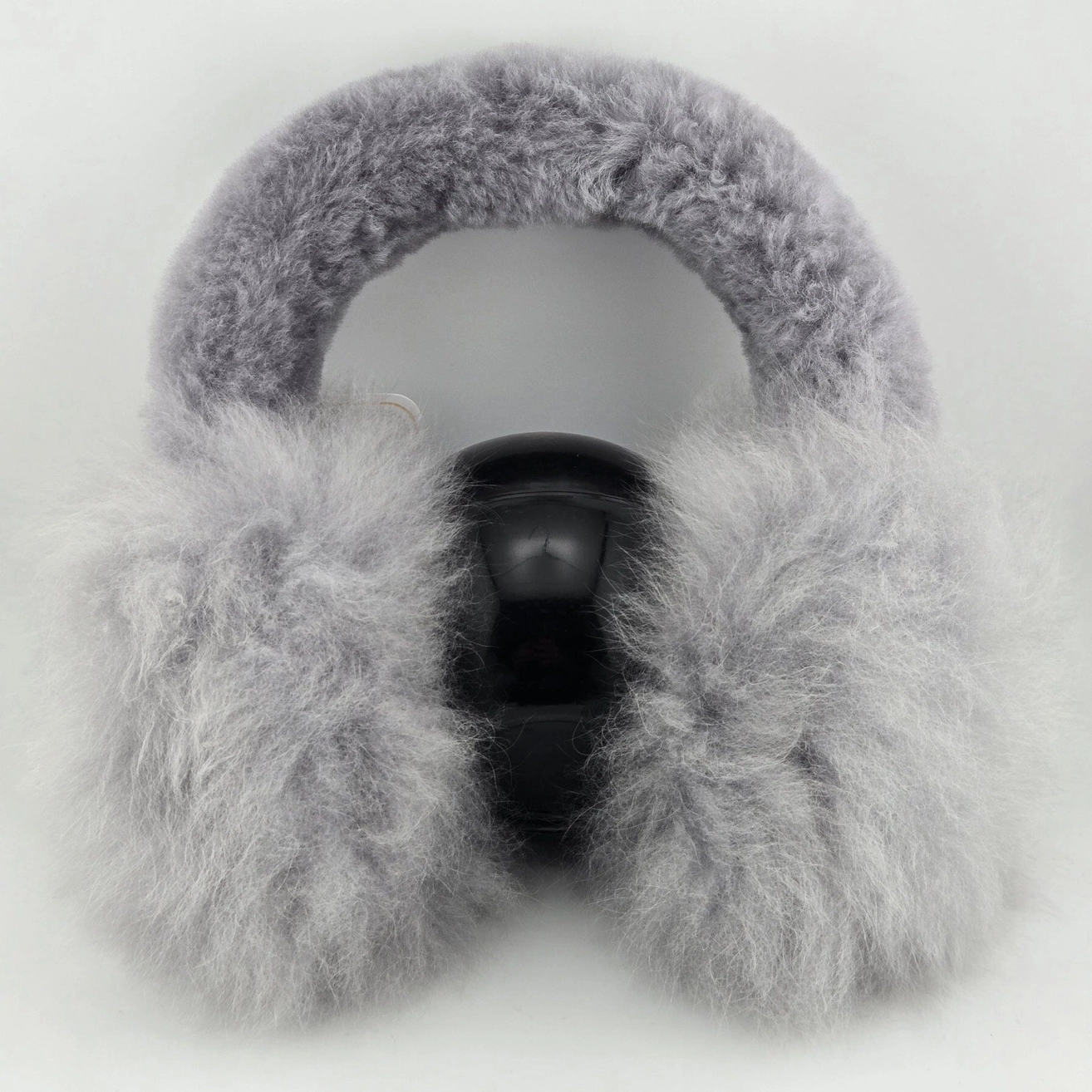 Light gray fluffy alpaca fur earmuffs shown on a plain light gray background.