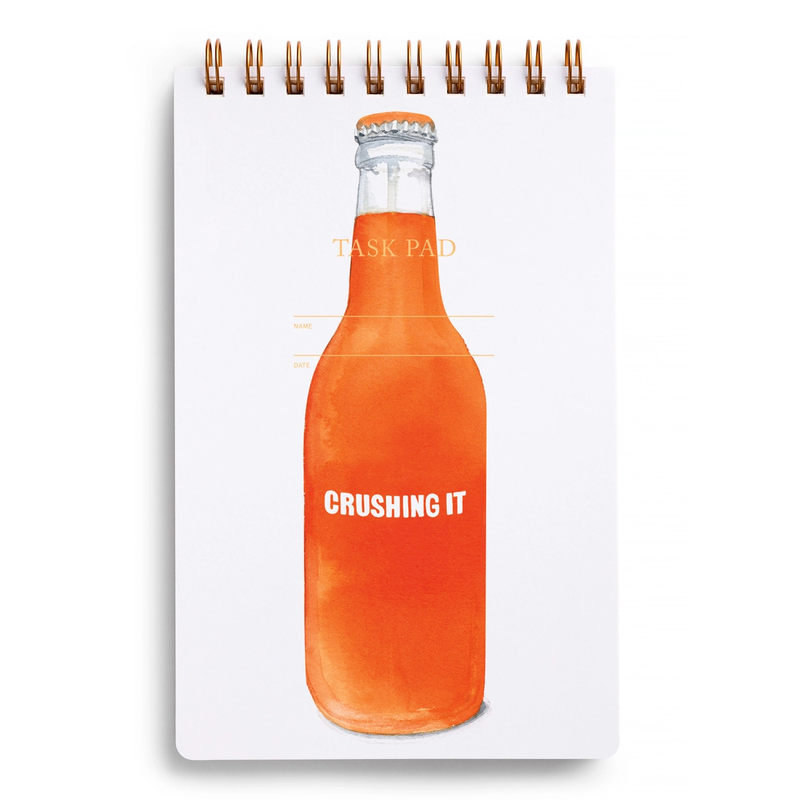 Notebook with an orange bottle design and 'CRUSHING IT' text on a white background