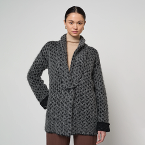 Woman wearing a textured gray coat against a plain background
