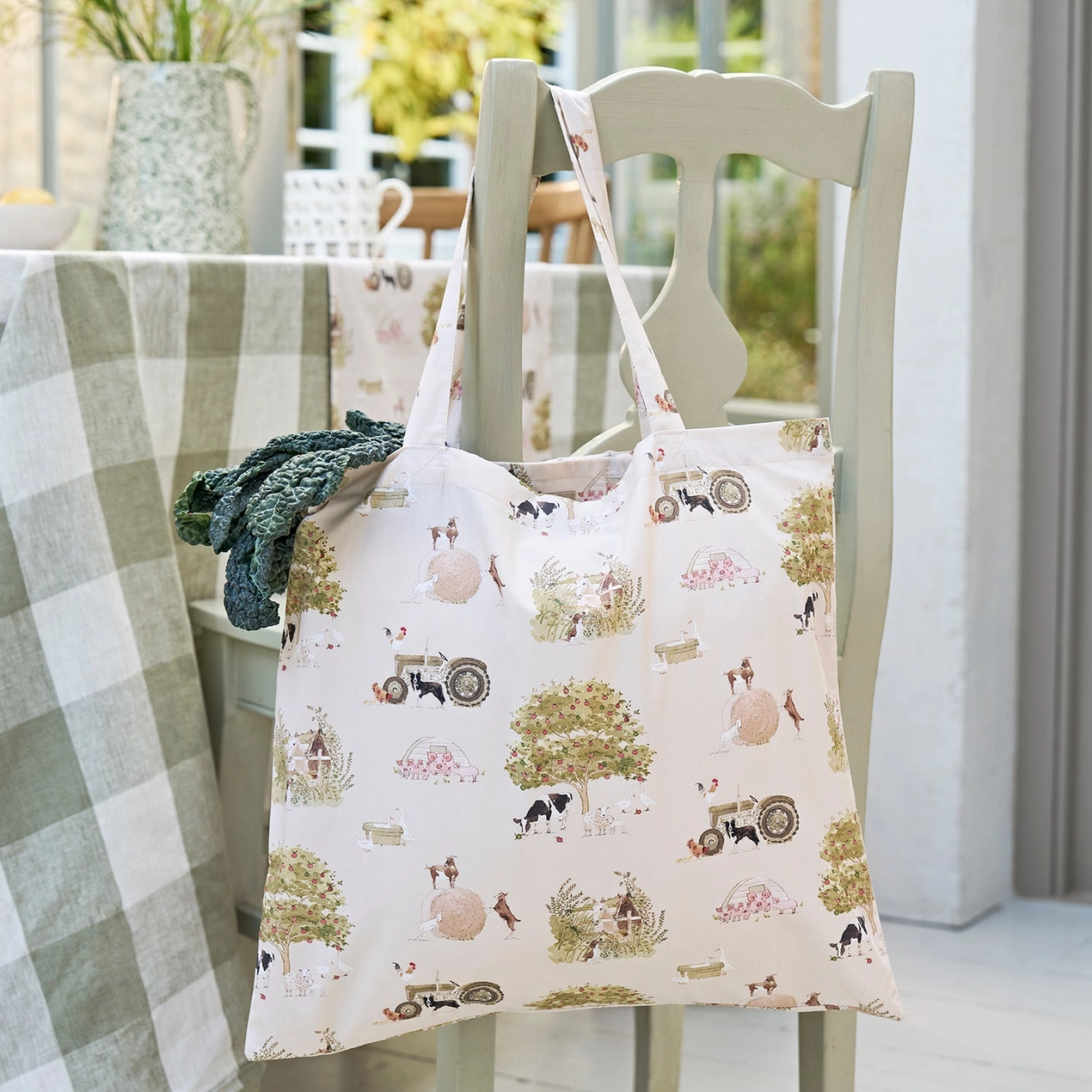 Tote bag with vintage farm design hanging on a chair outdoors