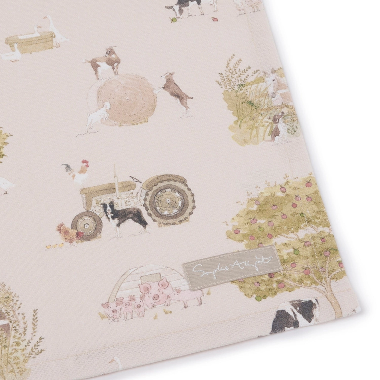 Tea towel with farm-themed design featuring tractors, animals, and nature elements on a light background.