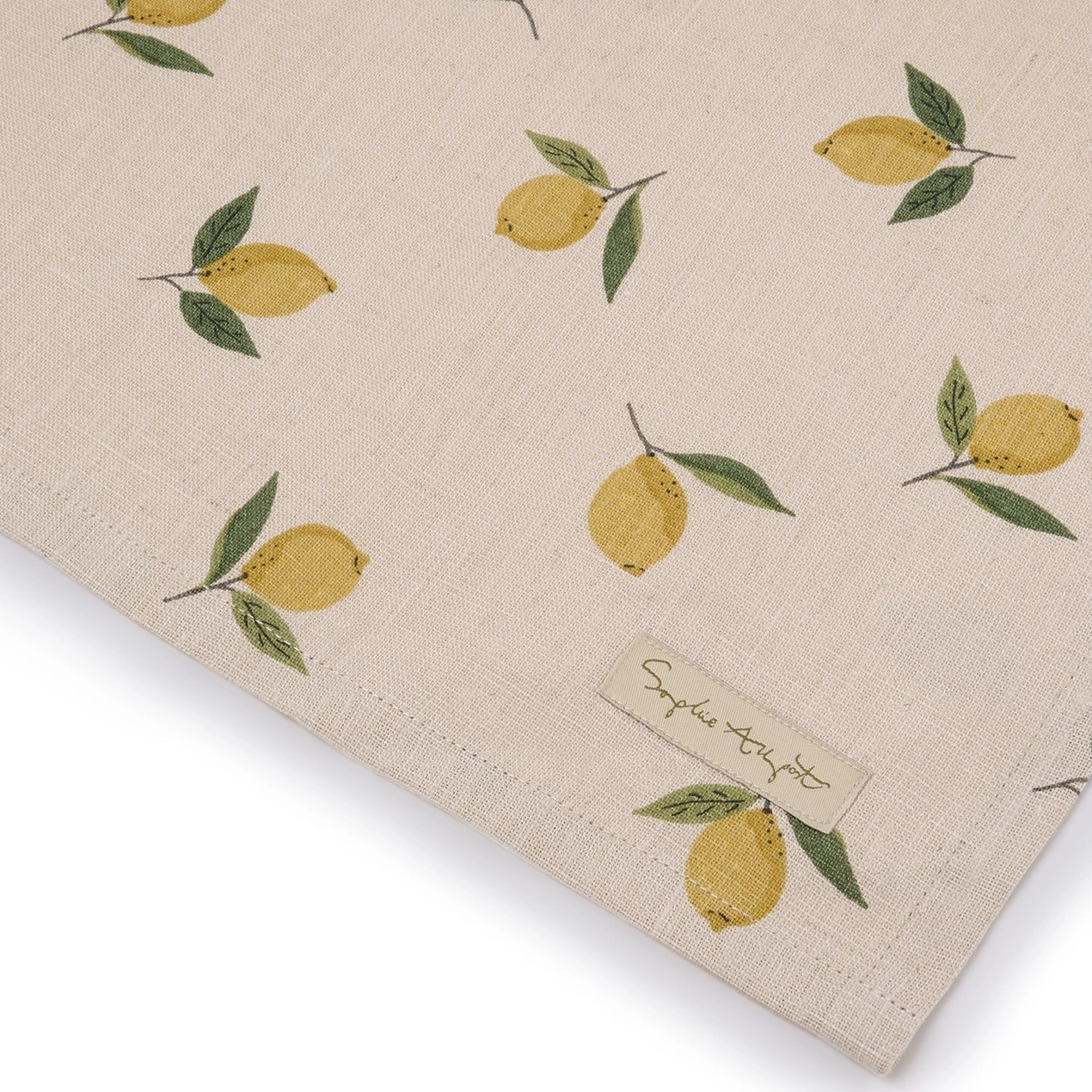 Beige tea towel with lemon pattern and a label on a white background