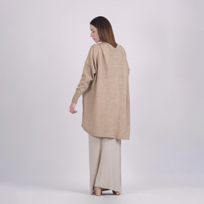 Woman wearing a beige long-sleeve top and pants on a white background