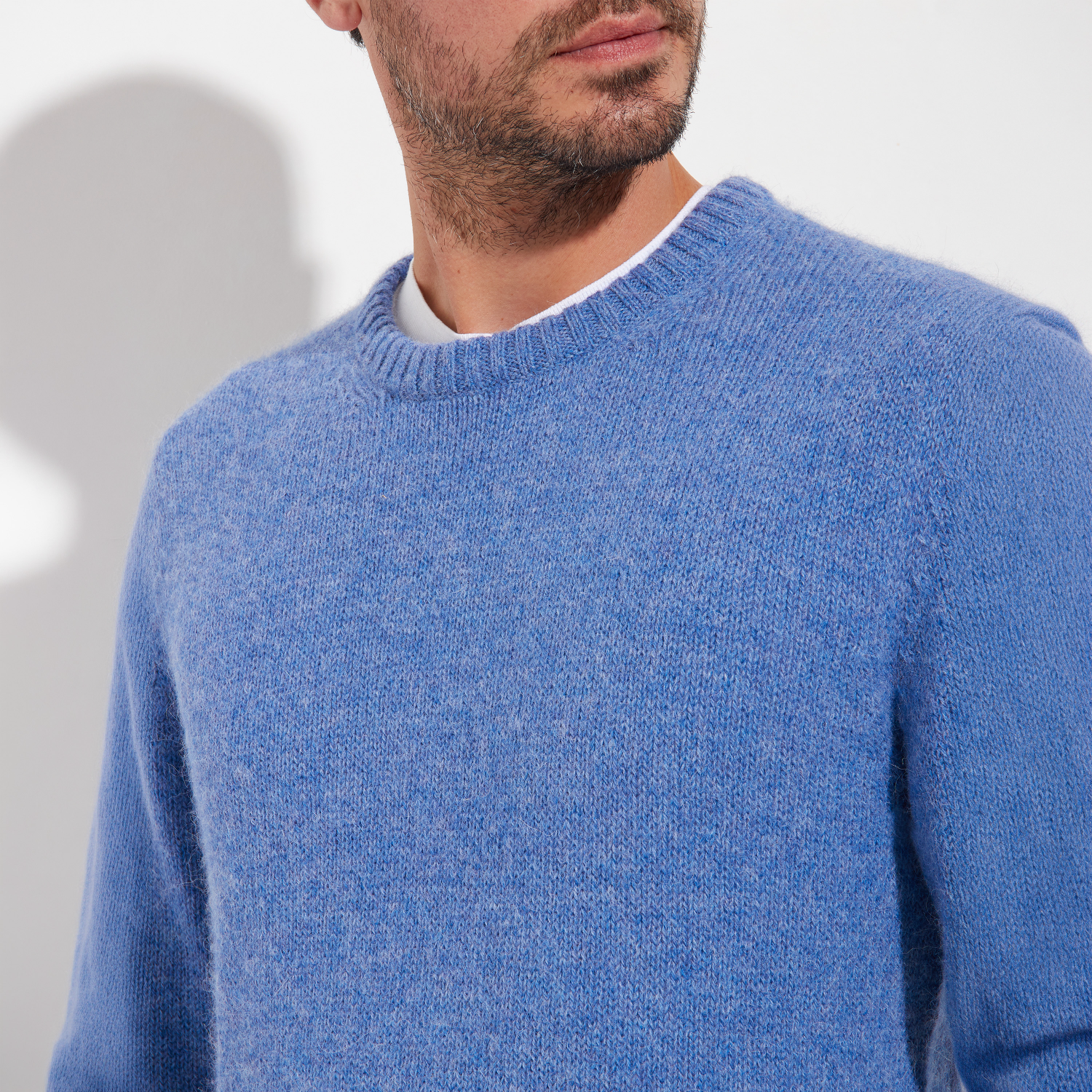 Man wearing a blue sweater against a plain background