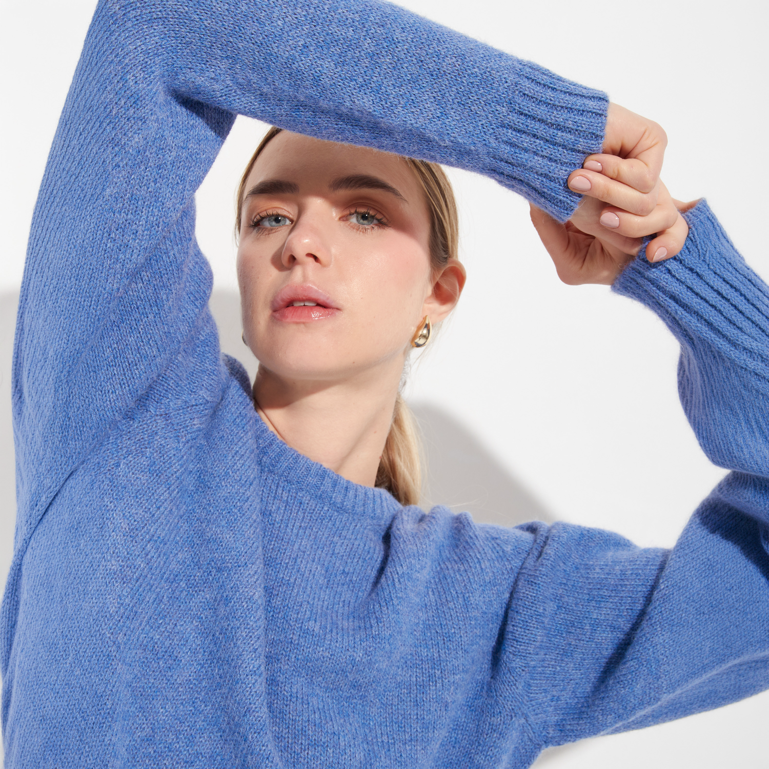 Woman wearing a blue sweater against a white background