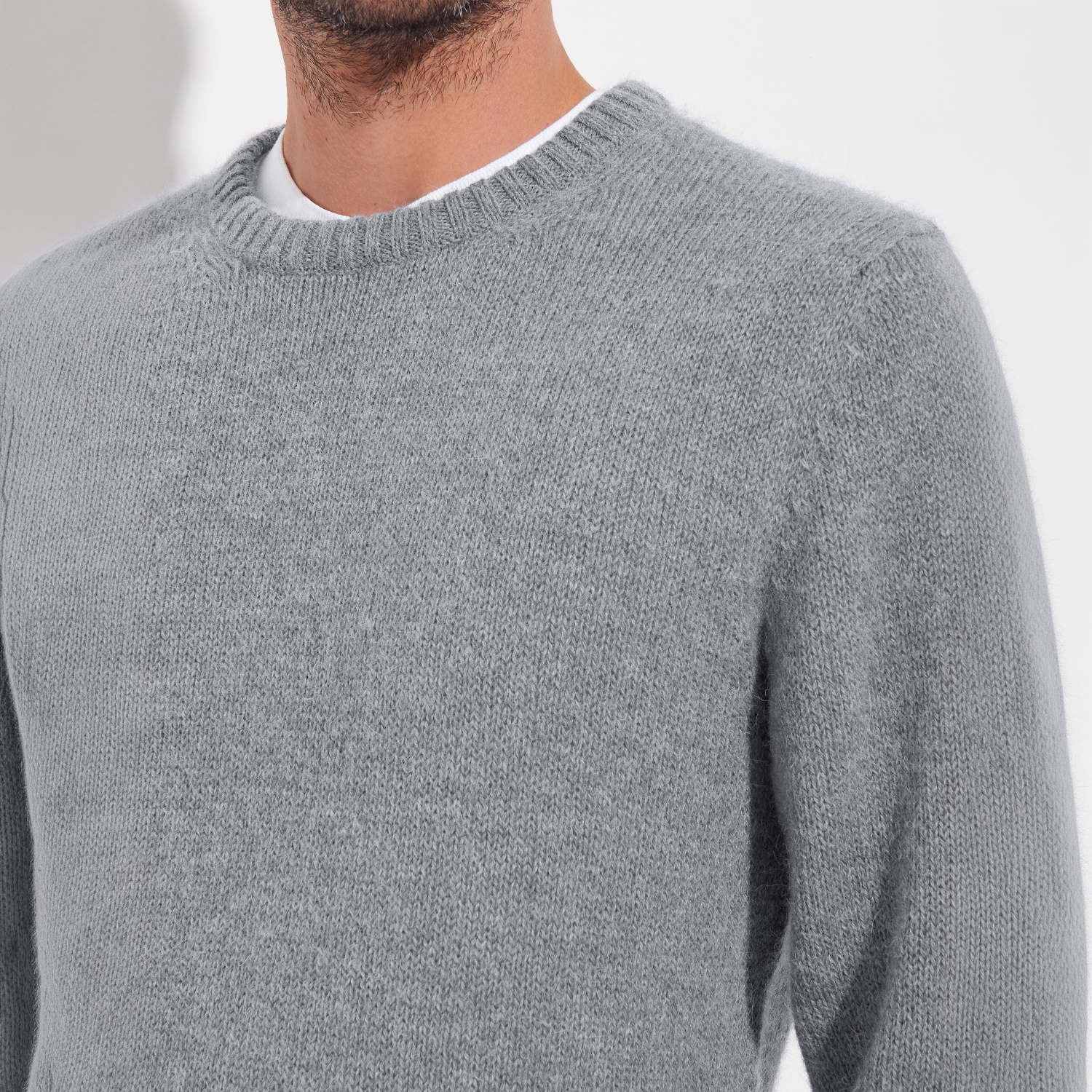 Gray sweater worn by a person on a white background