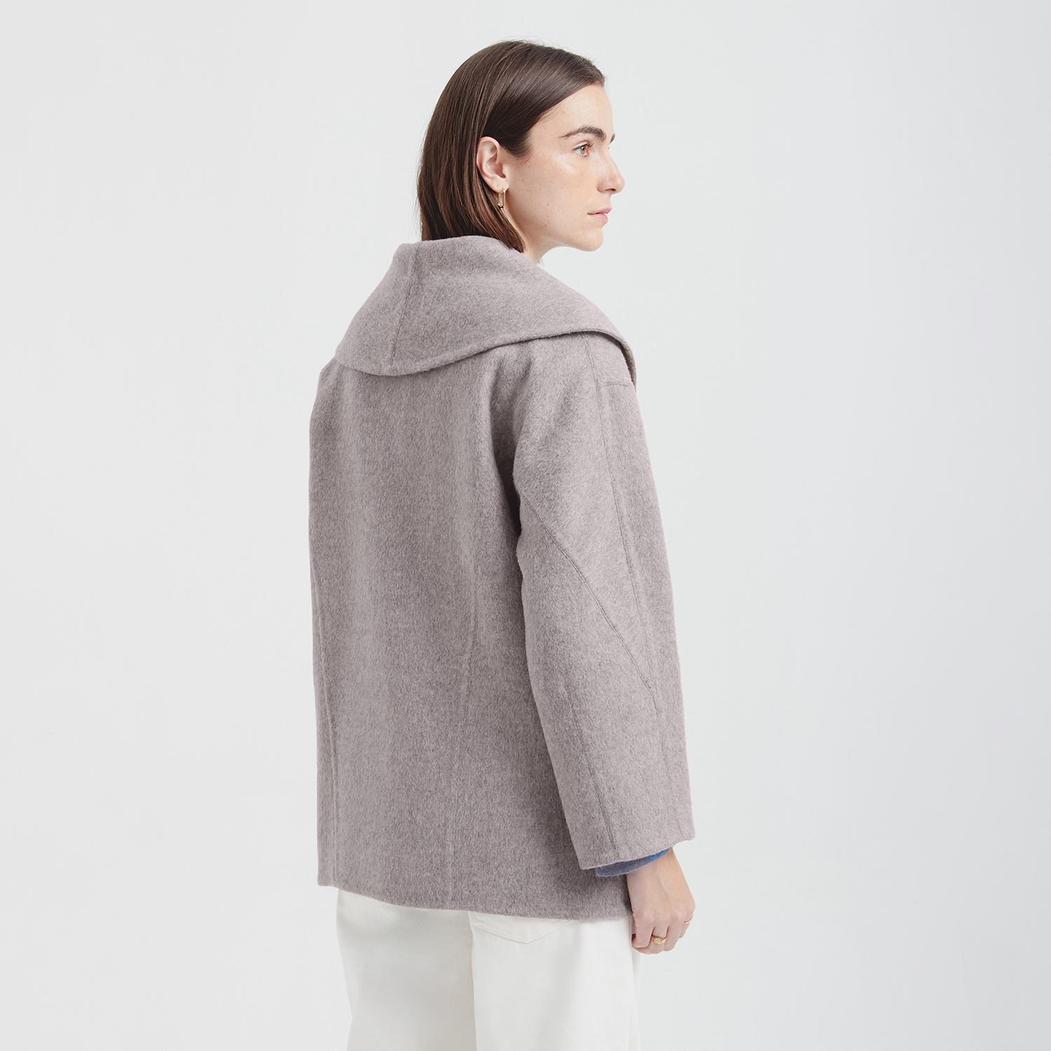 Woman wearing a gray coat on a white background
