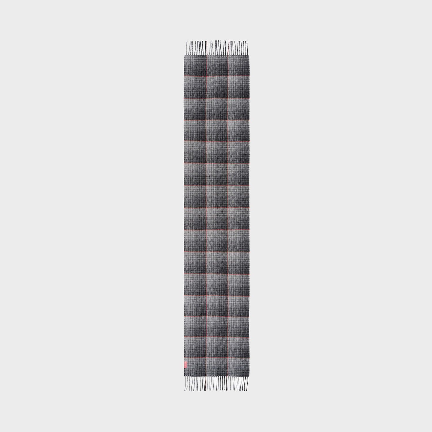 Grey plaid scarf with fringe and red accents on a neutral background.