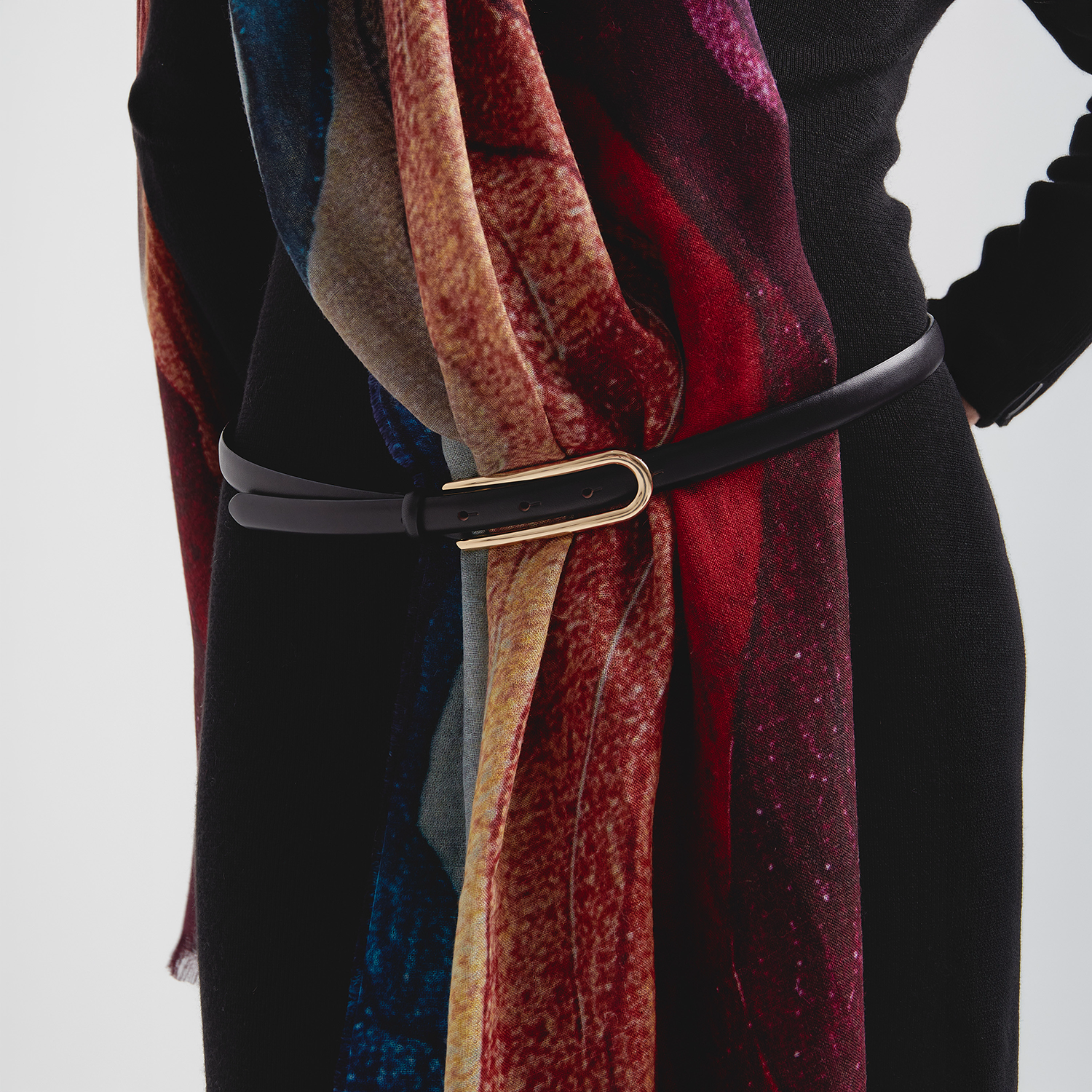 Colorful scarf with a black belt on a neutral background