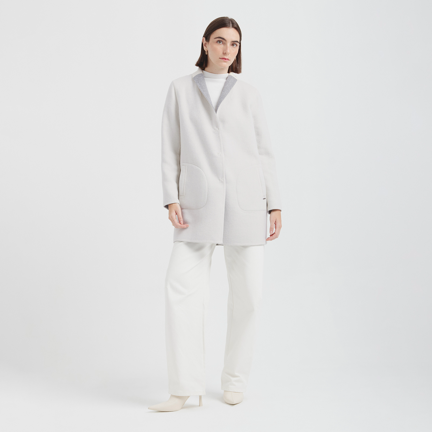 Person wearing a white coat and pants on a white background