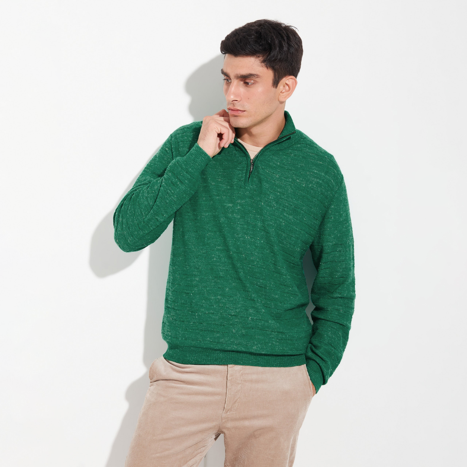 Man wearing a green sweater against a white background