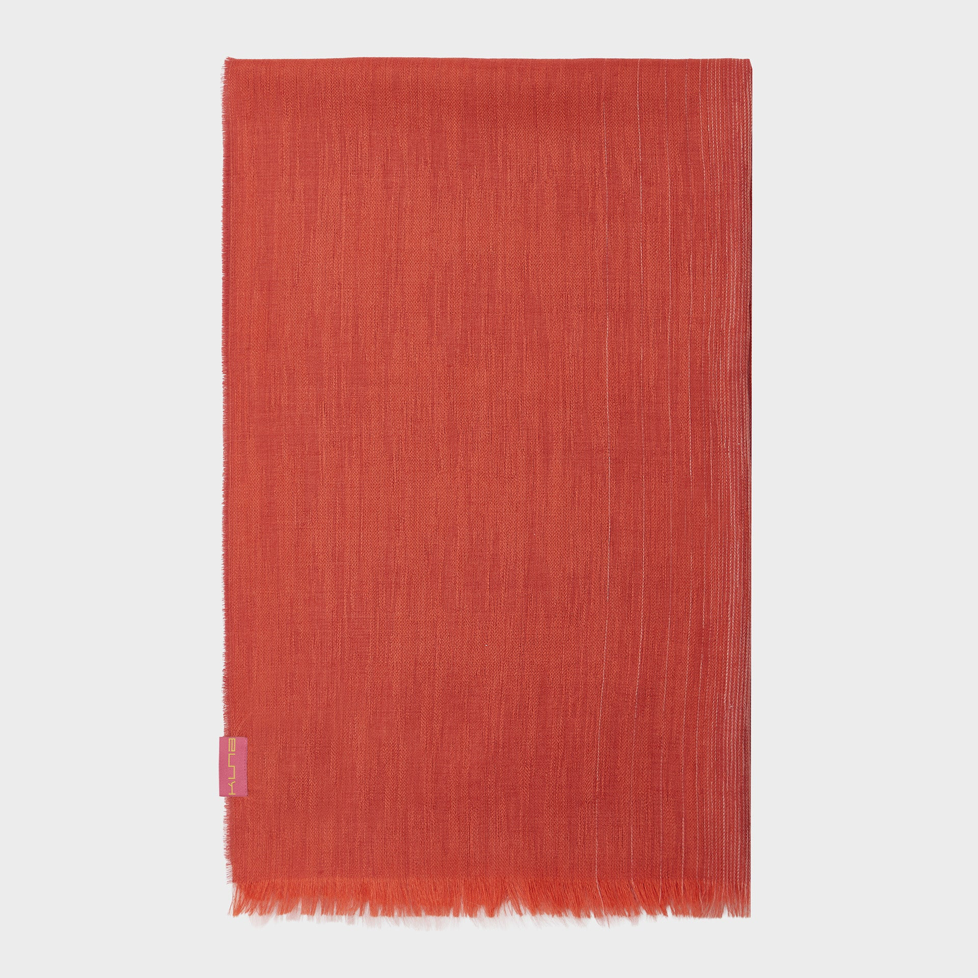 Red woven shawl with a small pink tag on a white background