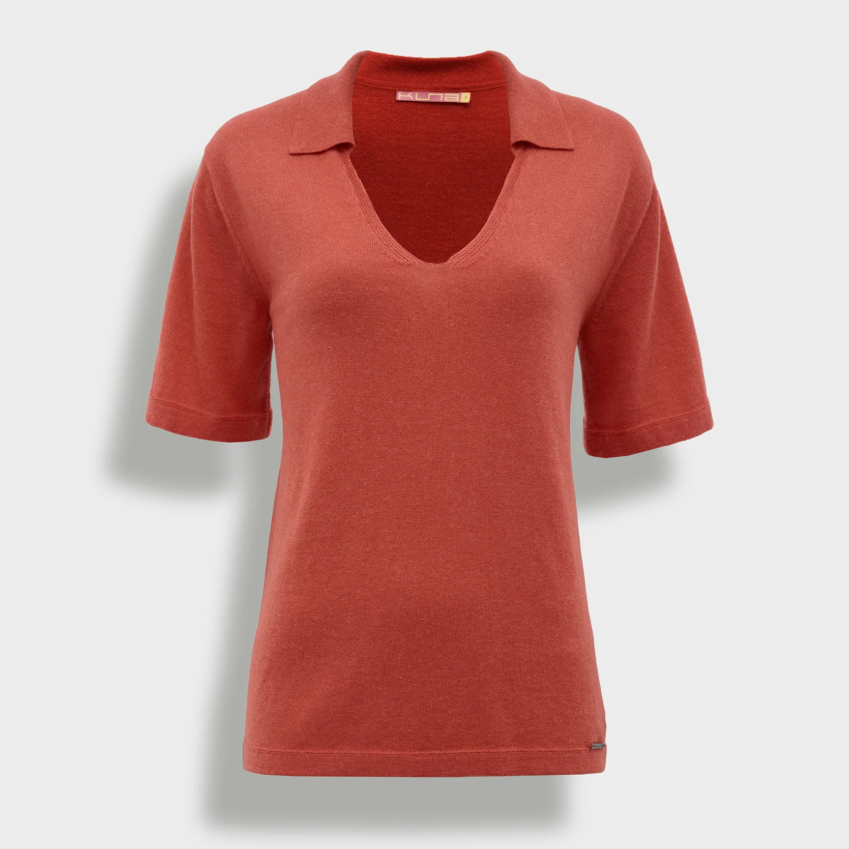 Orange polo shirt on a light gray background
