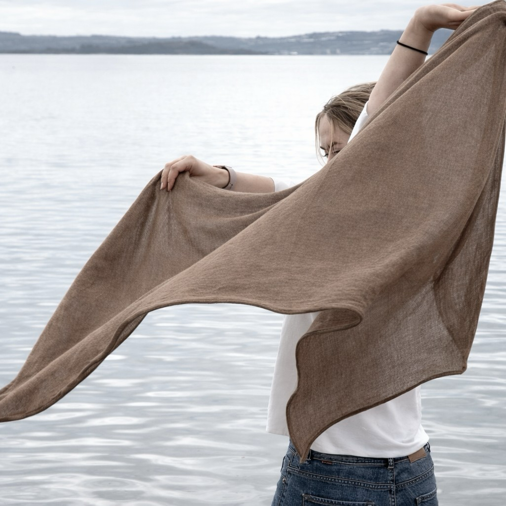 Person holding a brown wrap by a body of water