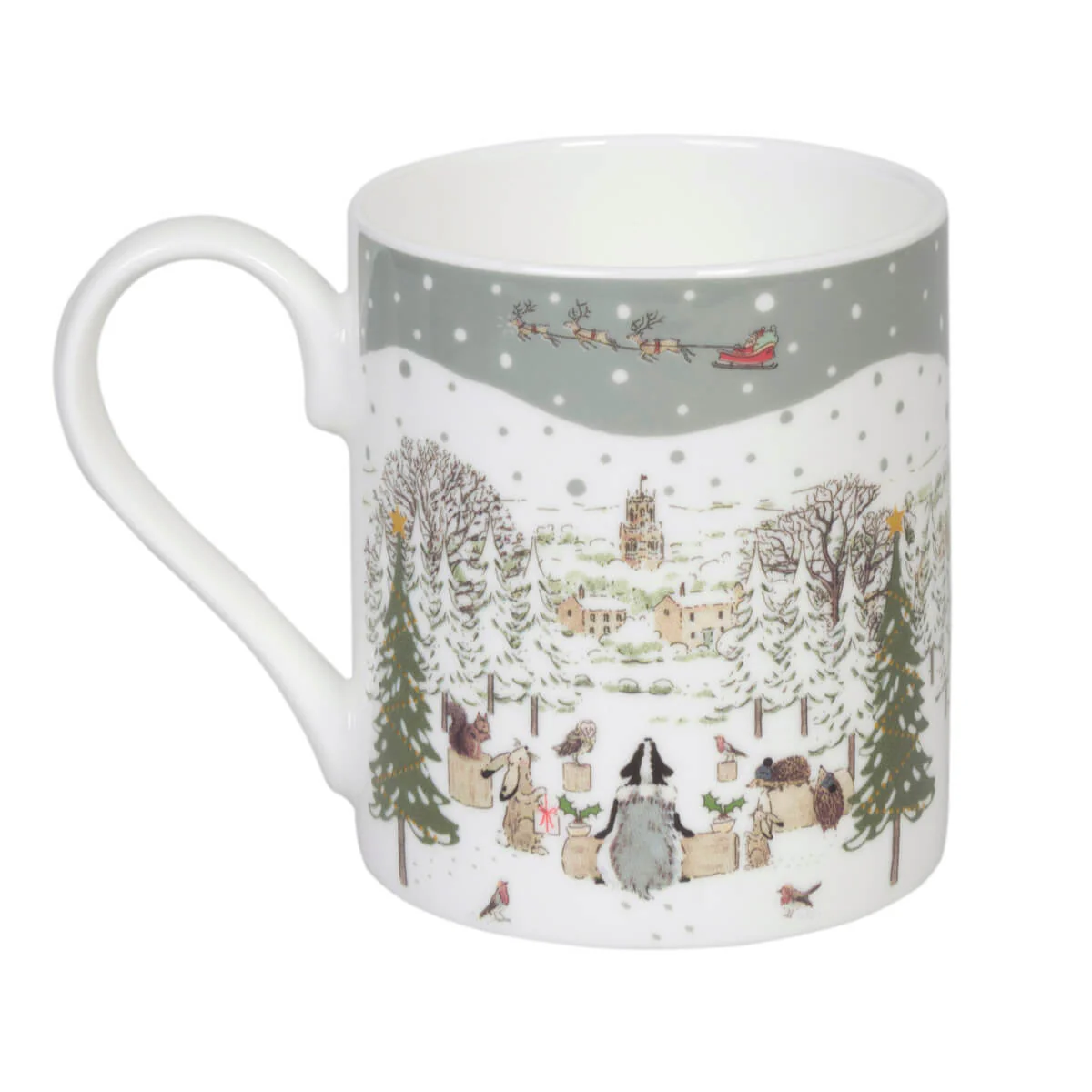 A white china mug featuring a detailed winter village illustration with snow-covered trees, small houses, animals, and Santa Claus in a sleigh against a gray snowy sky.