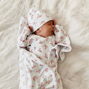 Take Me Home Outfit - baby in a white kimono style top and hat with mauve radish pattern on a neutral background