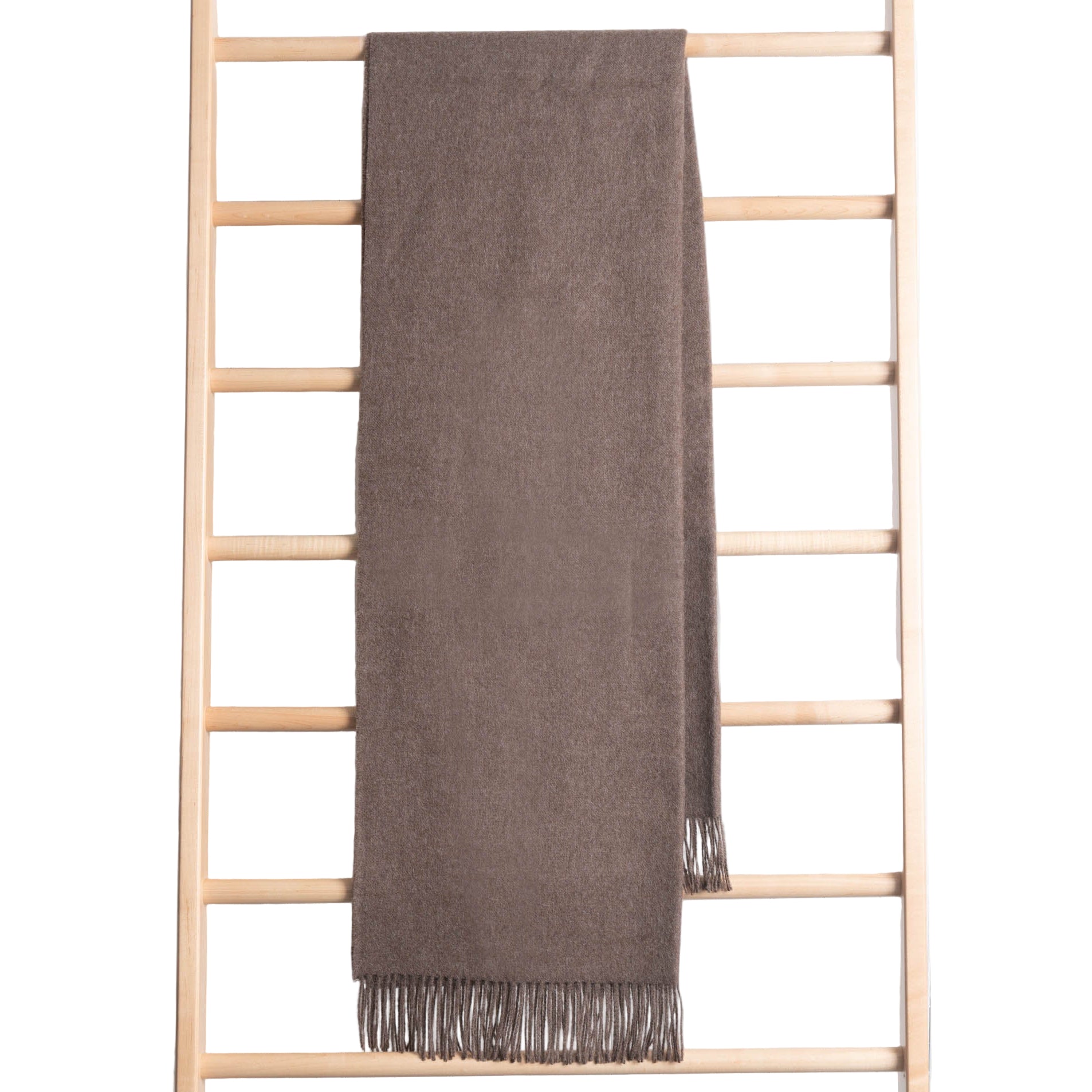 Brown throw draped over a wooden ladder on a white background