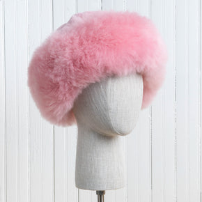 Premium Baby Alpaca Fur Hat. A pink Premium Baby Alpaca Fur Hat on a mannequin head against a white paneled background.