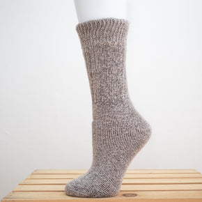 Andinista Alpaca Hiking Socks, a picture of a foot wearing a pair of purple alpaca hiking socks on a wooden crate.