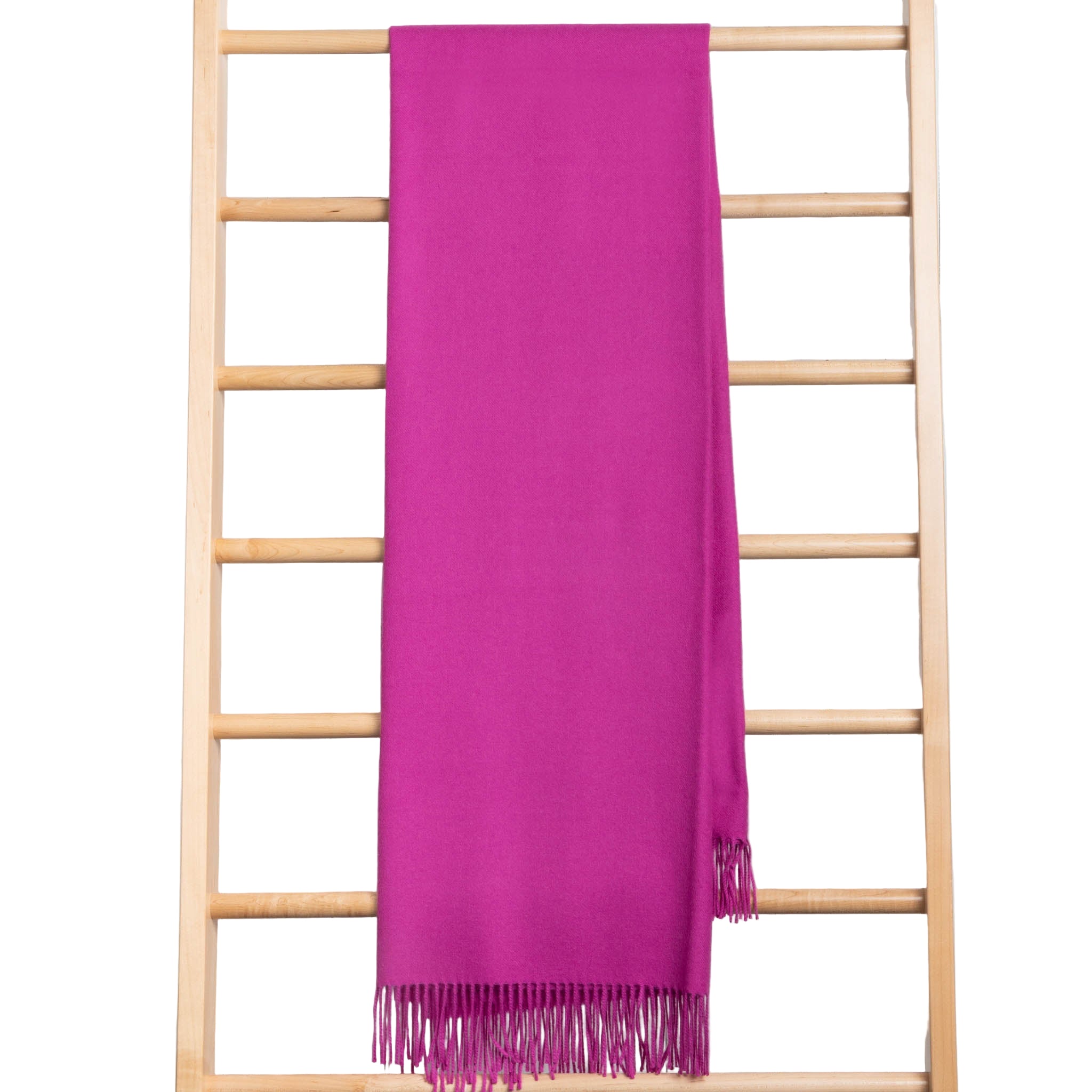 Purple throw with fringe on a wooden ladder against a white background