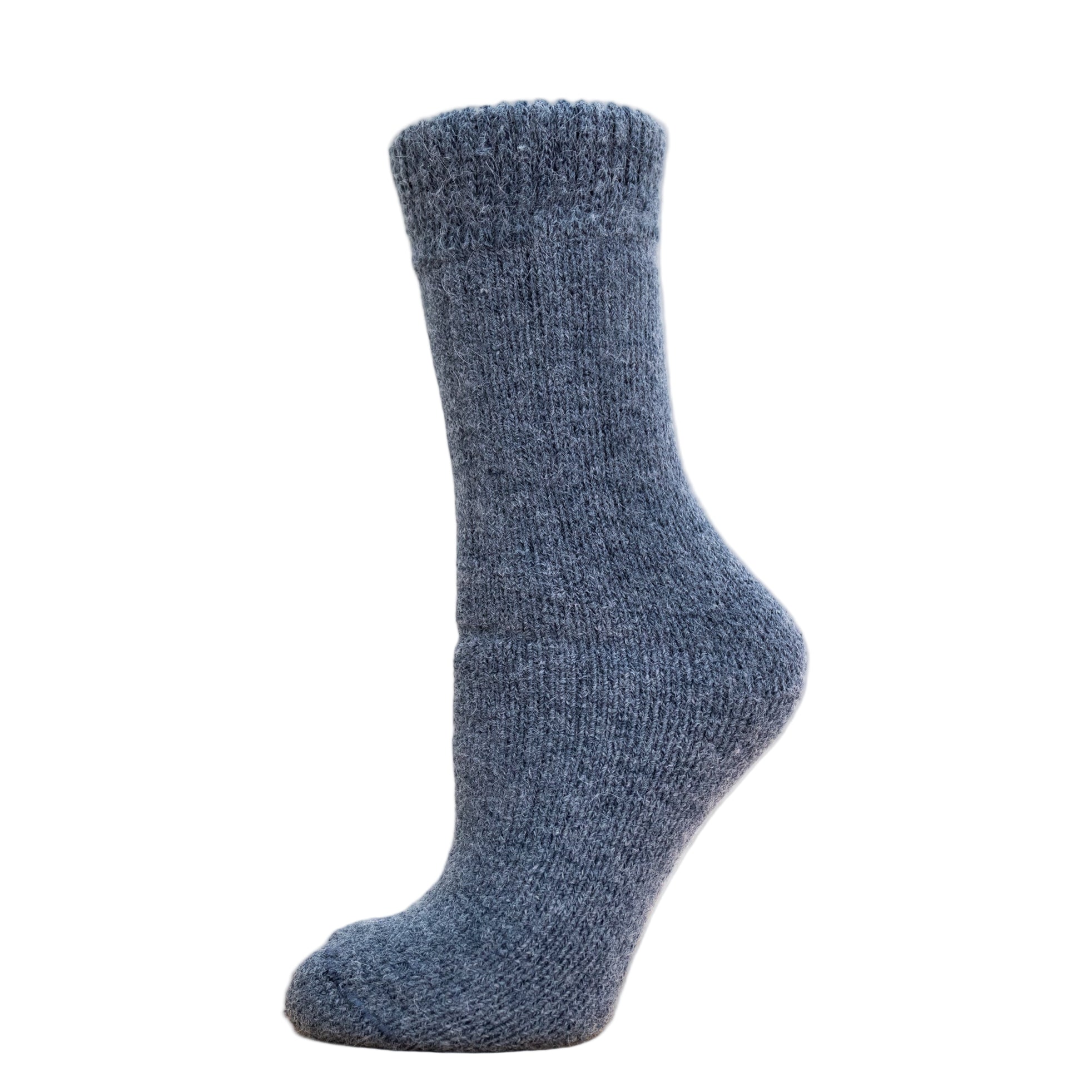 Andinista Alpaca Hiking Socks, a picture of a foot wearing a pair of denim alpaca hiking socks on a wooden crate.