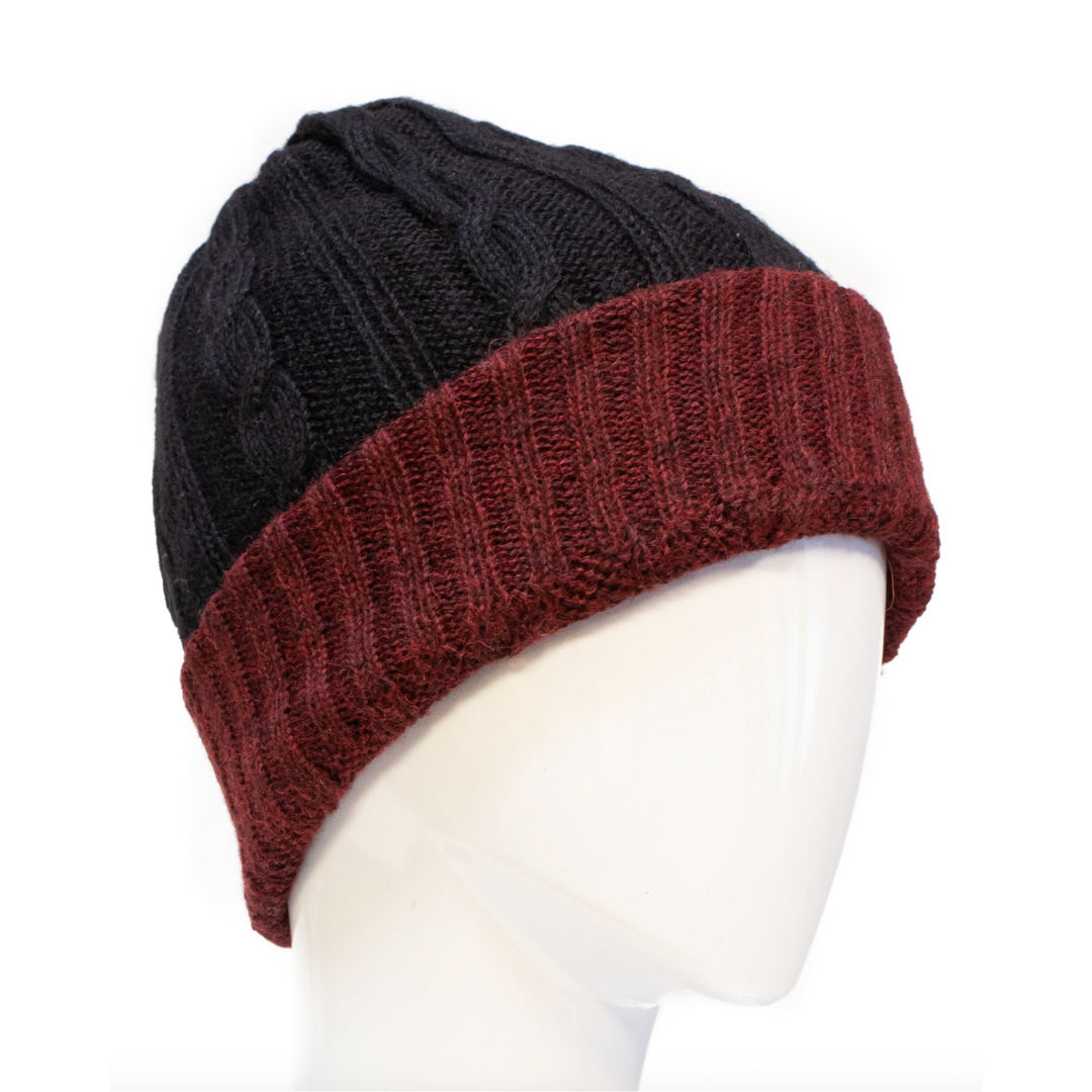 Two-tone black and red knitted beanie on a mannequin head against a white background