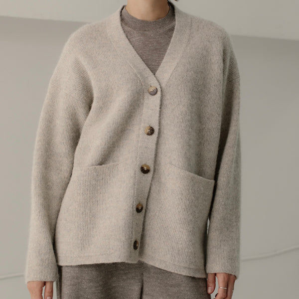 Bare Knitwear Harvest Cardigan. Someone wearing a gray baby alpaca cardigan in front of a neutral background.