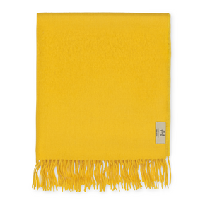 Yellow throw blanket with fringes on a white background