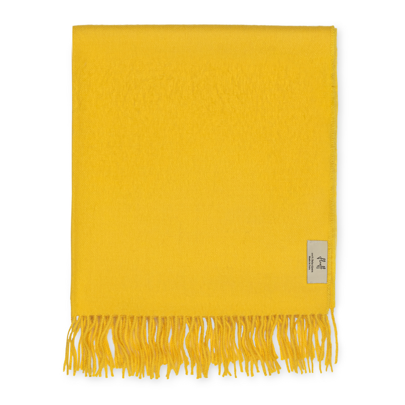 Yellow throw blanket with fringes on a white background