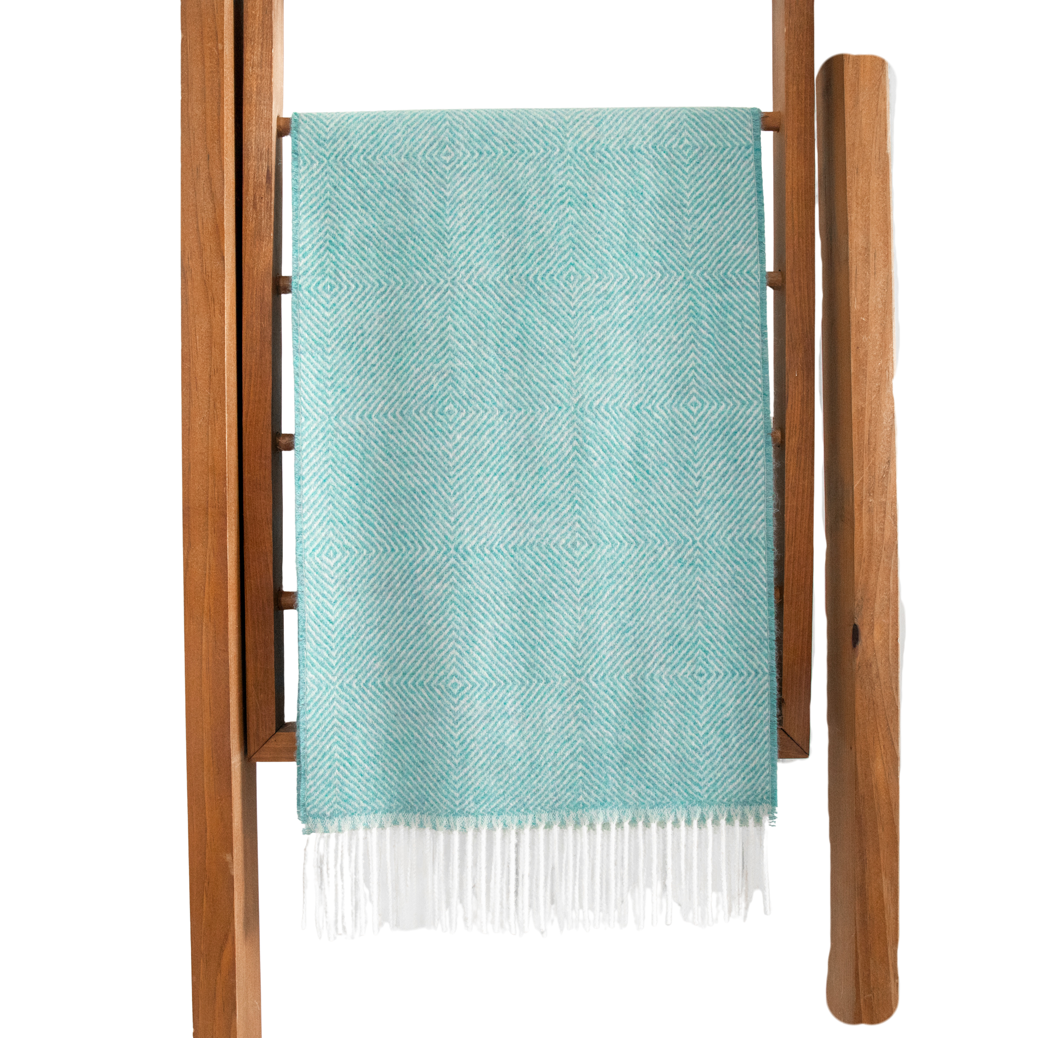 Teal woven blanket with white fringe draped over a wooden ladder