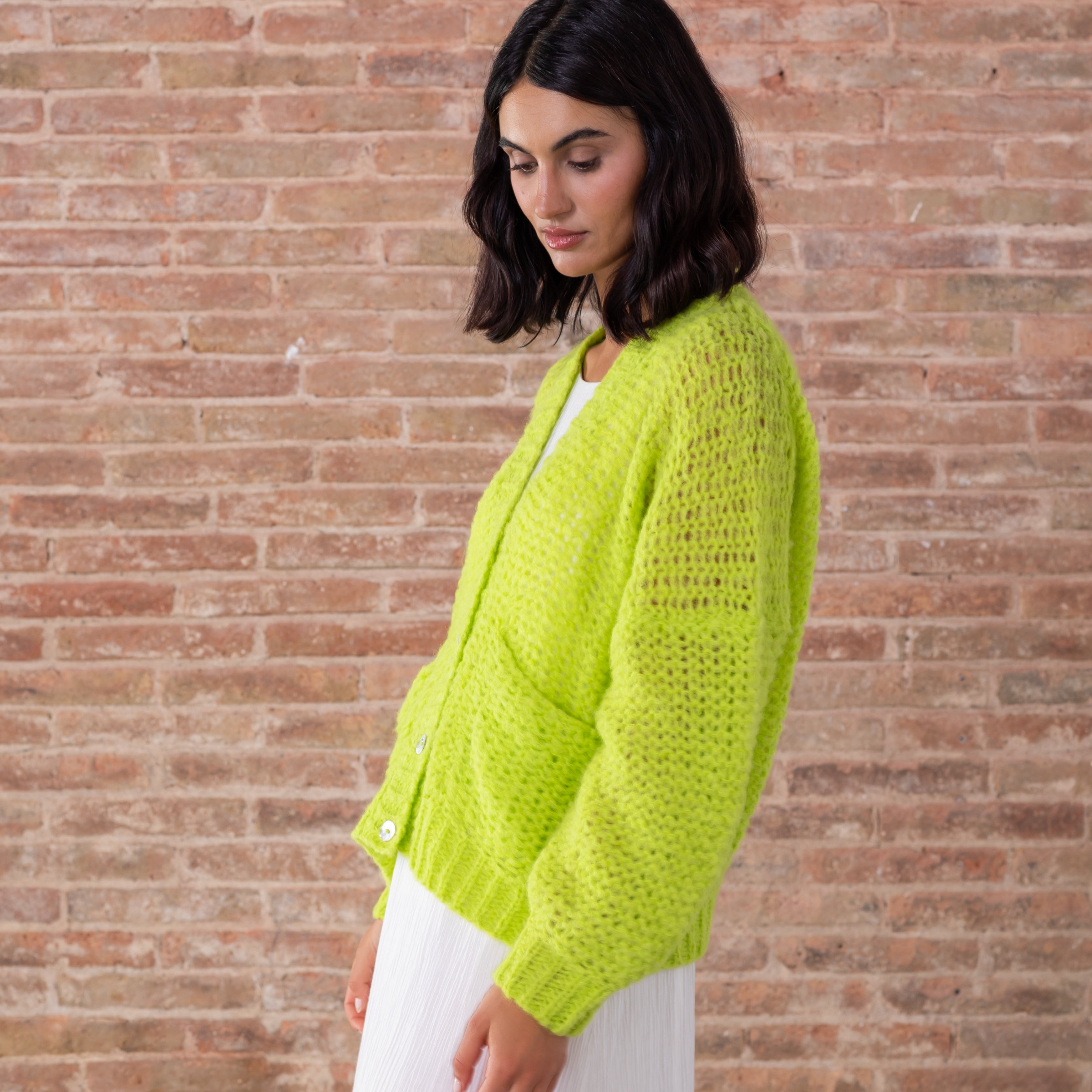 Light green baby alpaca cardigan v neck white buttons modeled side view