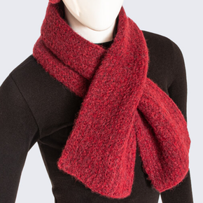 Red knitted scarf on a mannequin against a white background