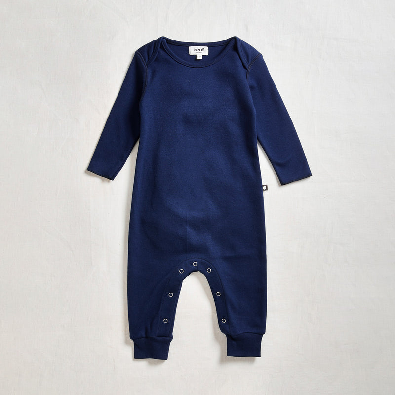 Oeuf Babies Lap Shoulder Jumper. Blue onesie against a neutral gray background.