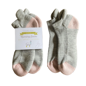 Pair of gray and pink socks with a label on a white background