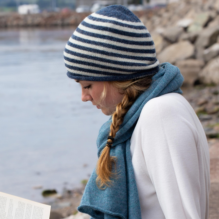 Person reading a book by a lakeside
