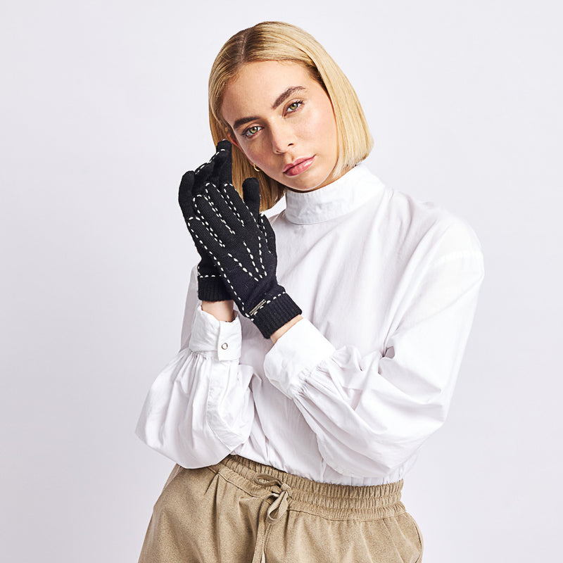 Kuna Willa Alpaca Gloves - model wearing black gloves with white stitching on a neutral background