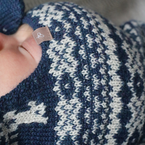 Close-up of a blue and white patterned knitted item with a brand tag.