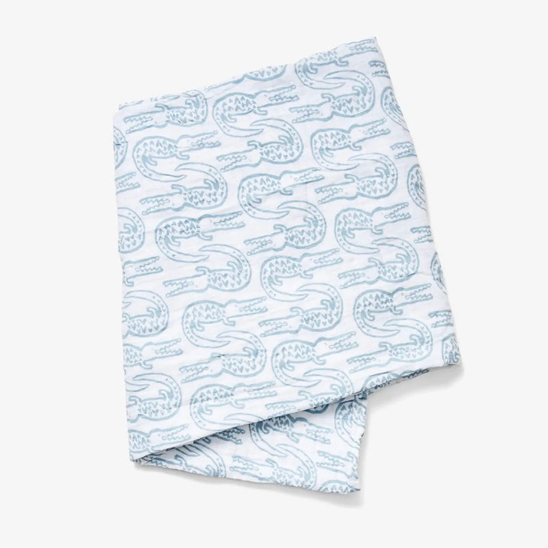 Baby Swaddle - white baby swaddle with blue alligator print on a neutral background