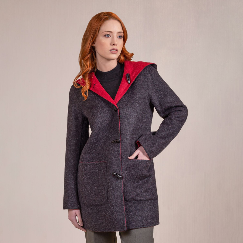 Kuna Anastasia Reversible Coat - model wearing black coat with red lining, toggle buttons, hood, and front pockets