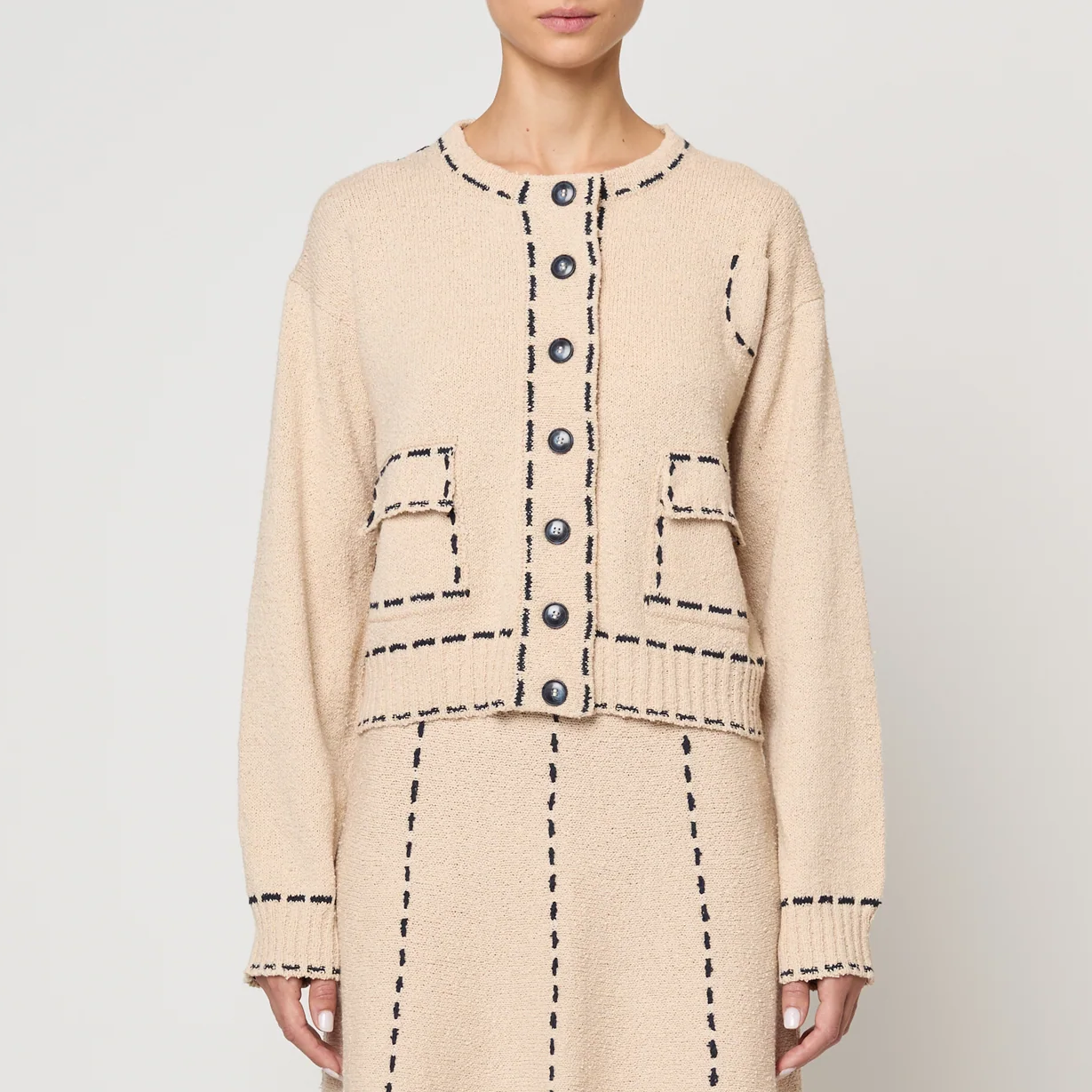 Beige two-piece suit with matching skirt and jacket on a white background