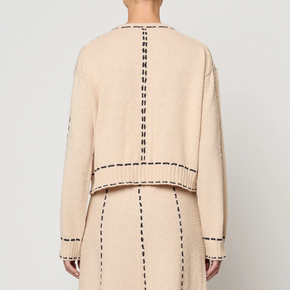 Beige two-piece suit with navy detailing on a white background