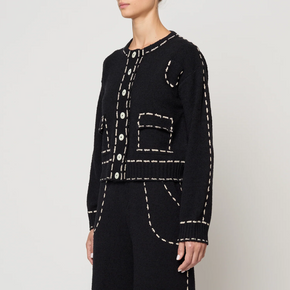 Black outfit with tan stitching on a plain background