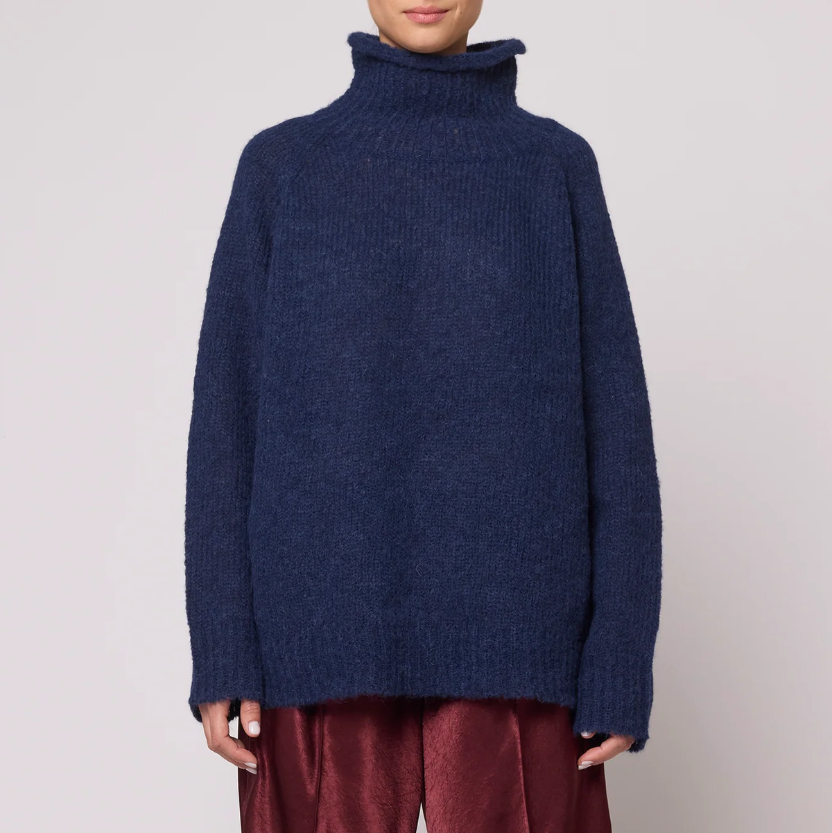 A woman wearing a navy blue knit turtleneck sweater.