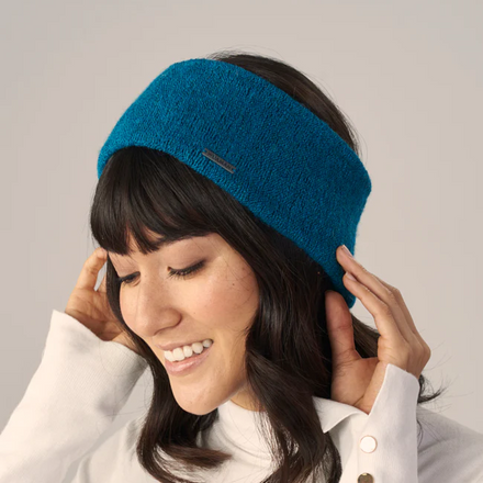 Woman wearing a blue headband against a plain background